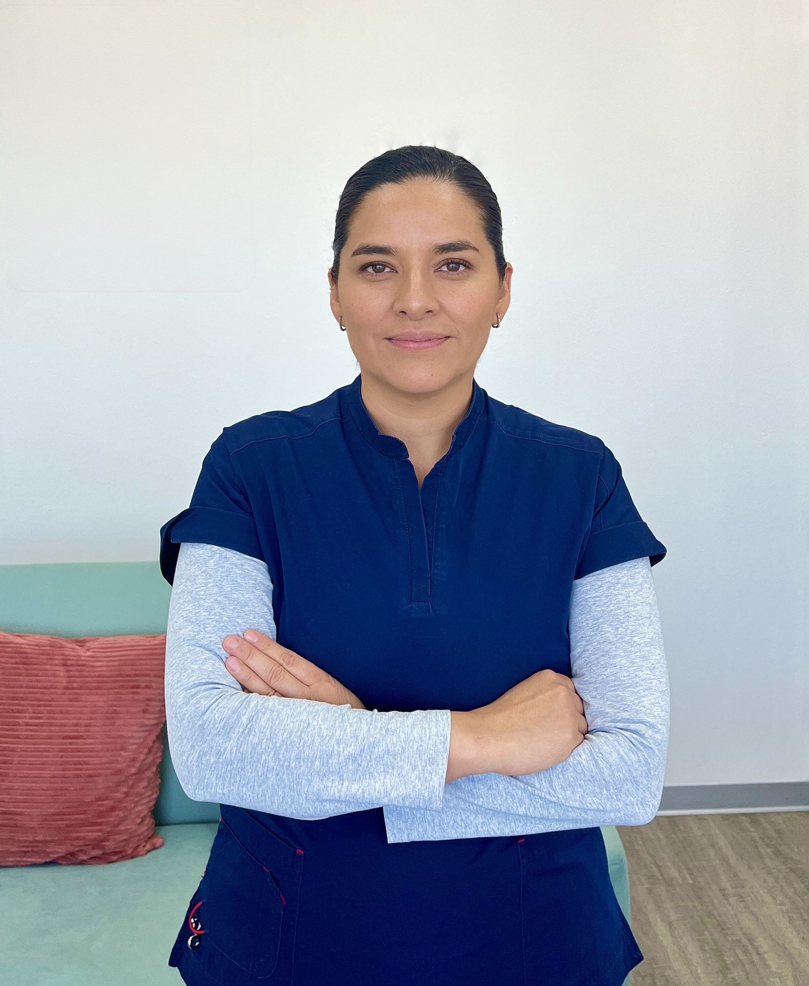 Primer plano de la dra tania perez marmolejo con un scrub azul y los brazos cruzados